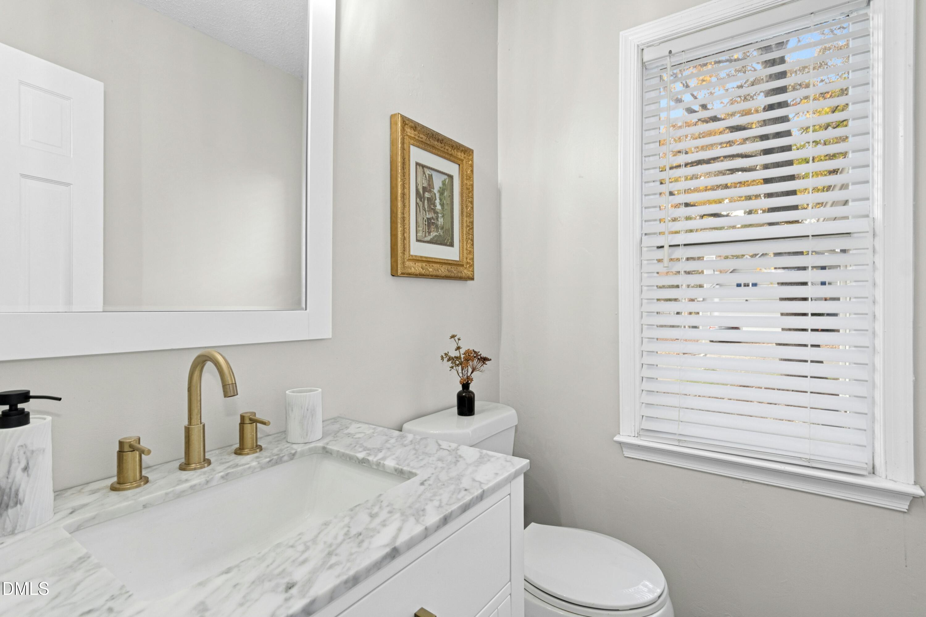 8616 Vanburgh Court Raleigh, NC 27615 - Photo 18 of 38 a bathroom with a granite countertop sink toilet and mirror