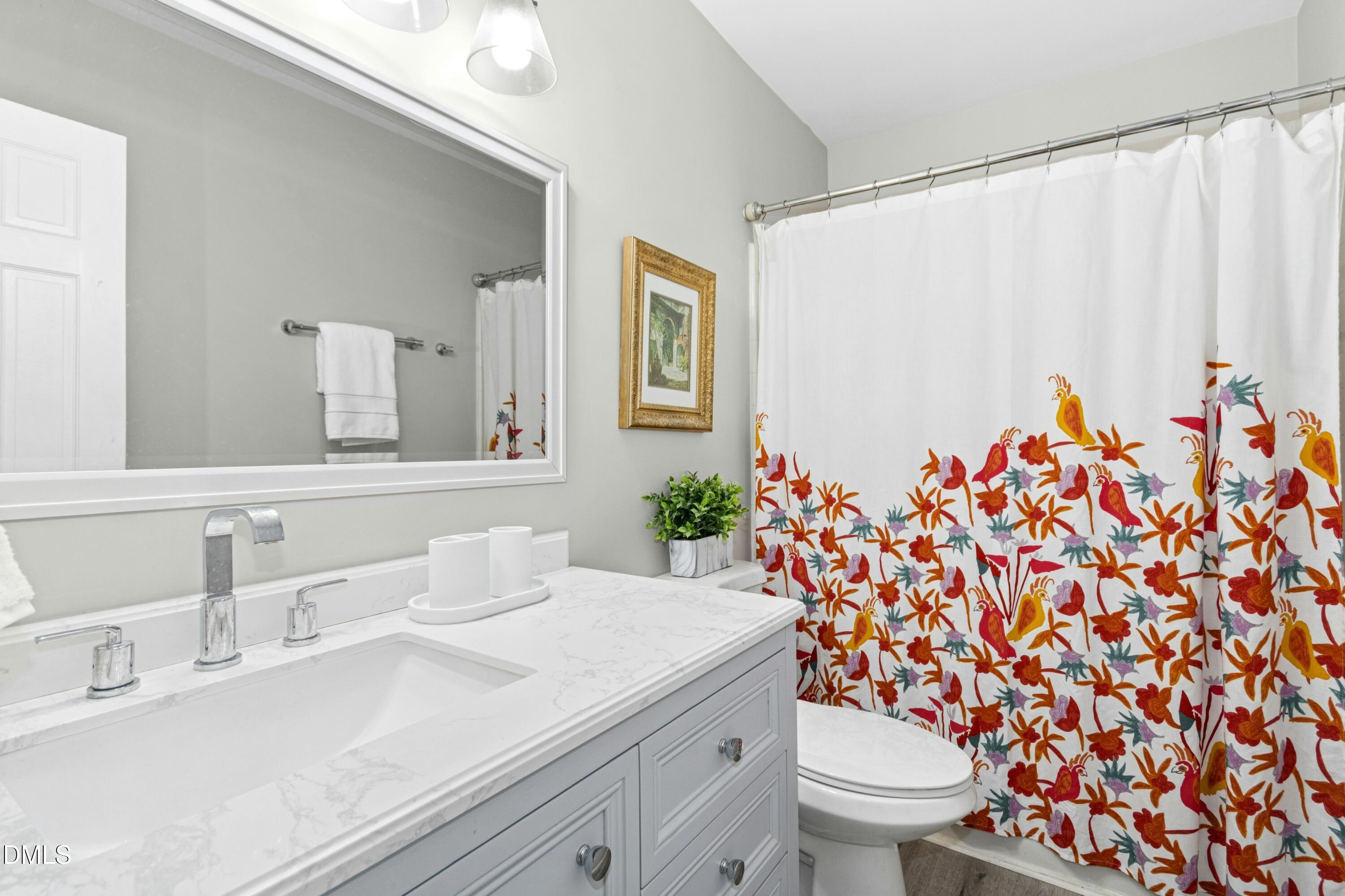 8616 Vanburgh Court Raleigh, NC 27615 - Photo 21 of 38 a bathroom with a sink toilet and mirror