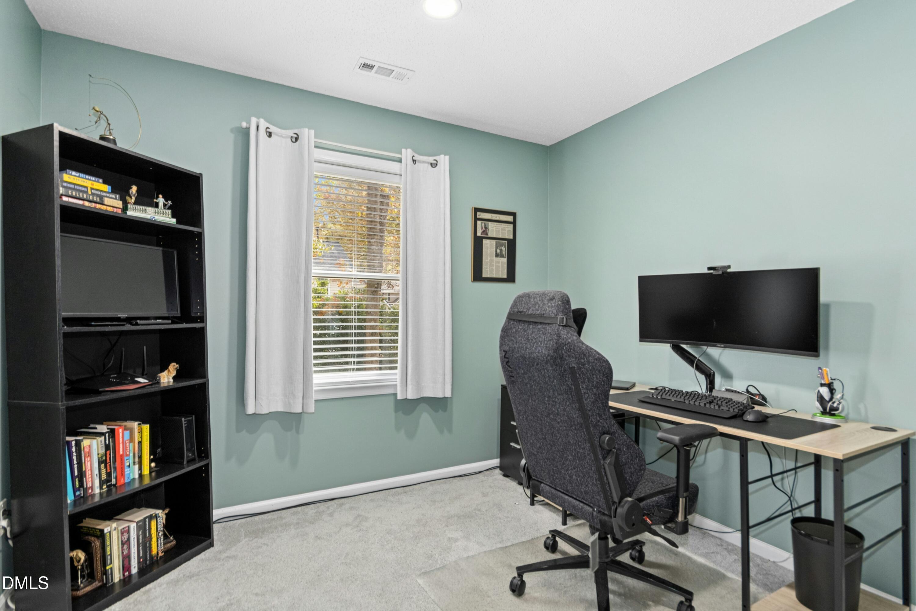 8616 Vanburgh Court Raleigh, NC 27615 - Photo 22 of 38 a view of a workspace with furniture and a bookshelf