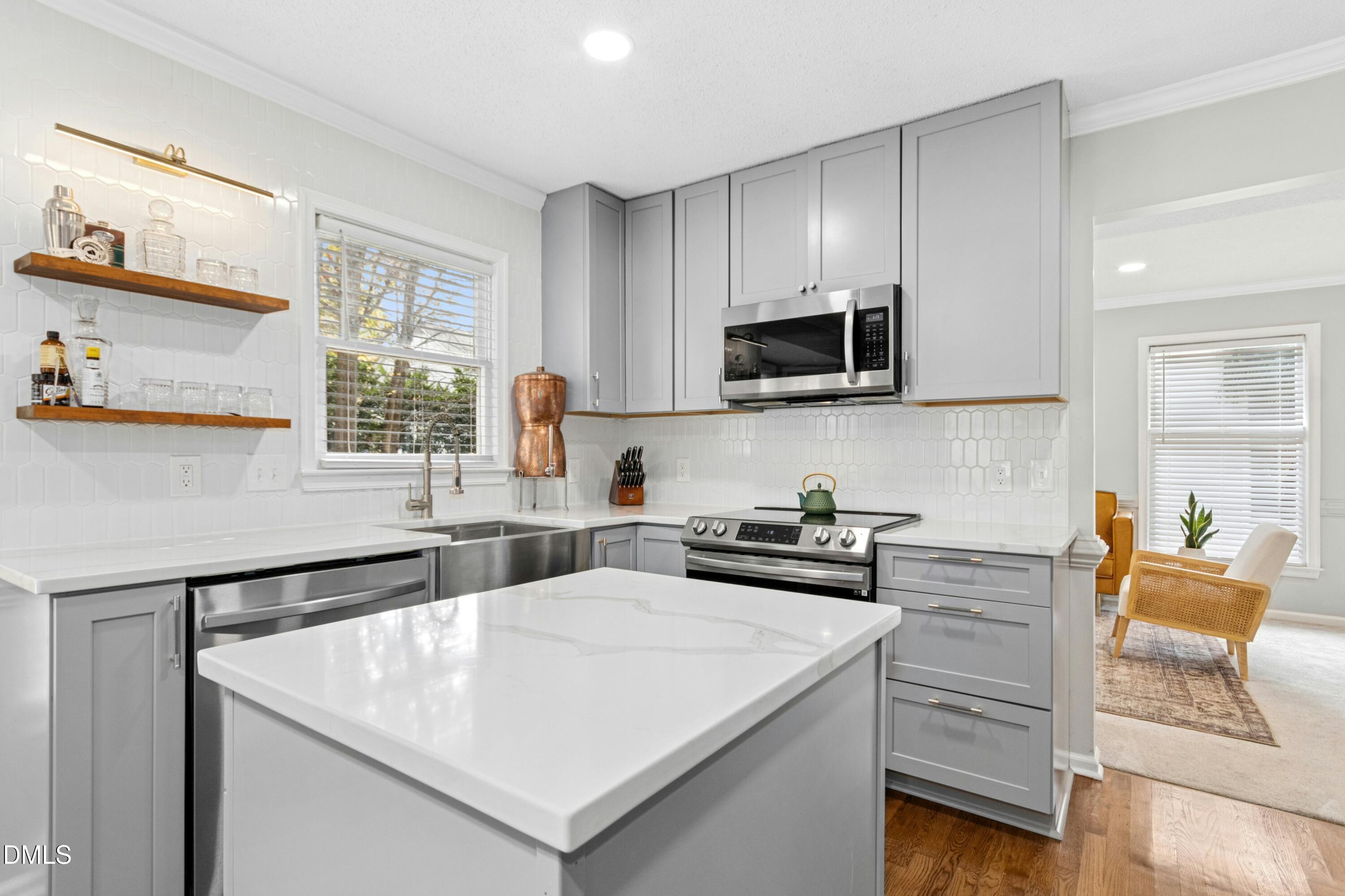 8616 Vanburgh Court Raleigh, NC 27615 - Photo 10 of 38 a kitchen with a stove a sink and a microwave