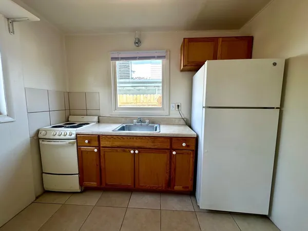 a kitchen with a refrigerator sink stove and cabinets