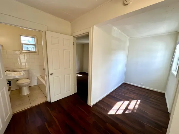 a view of a room with wooden floor and a toilet