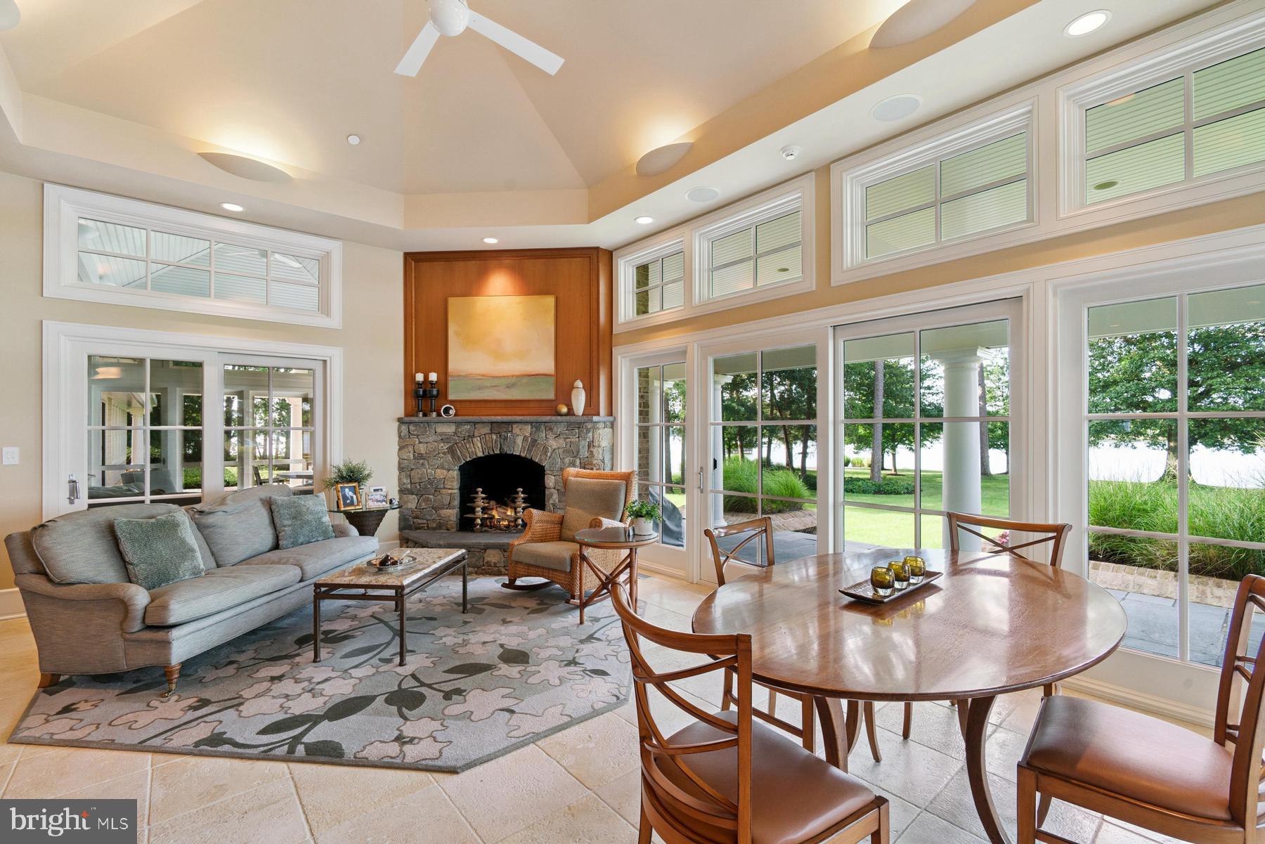 7090 Cooper Point Road Bozman, MD 21612 - Photo 24 of 86 a living room with fireplace furniture and a floor to ceiling window