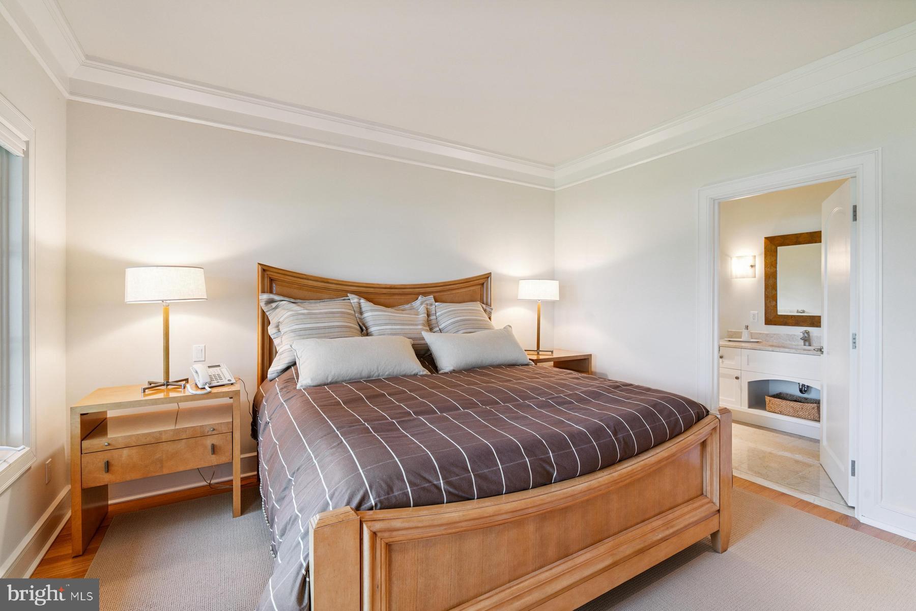 7090 Cooper Point Road Bozman, MD 21612 - Photo 45 of 86 a bedroom with a bed and a lamp on table