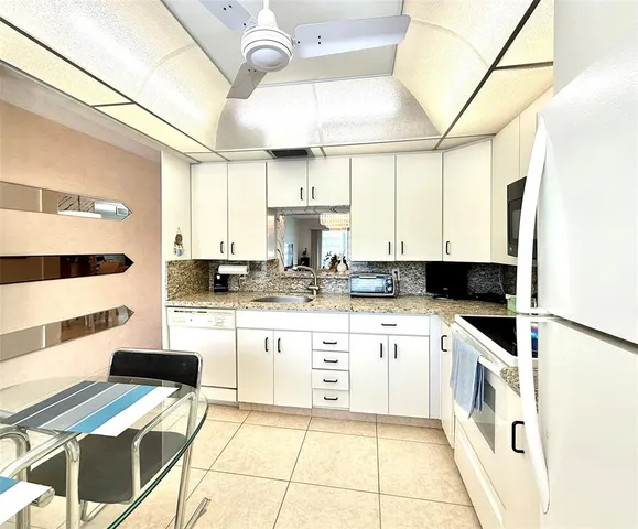 a kitchen with kitchen island granite countertop a sink and a stove