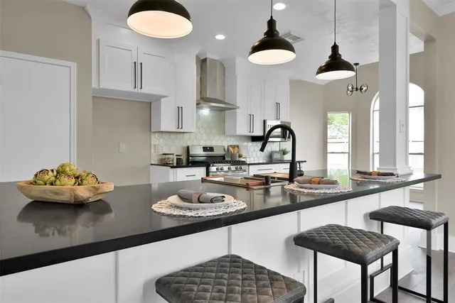 a kitchen with a sink a stove and chairs