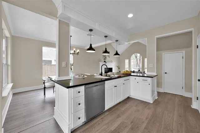 a kitchen with granite countertop a sink cabinets and wooden floor