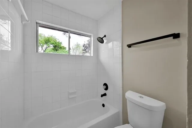 a white bath tub sitting next to a toilet