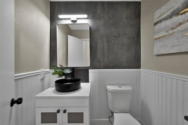 a bathroom with a sink a toilet and mirror