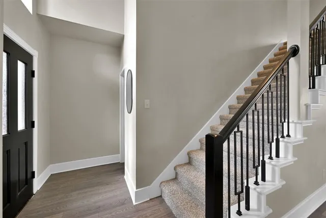 an entryway with wooden floor and stairs