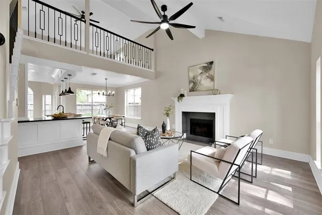 a living room with furniture a fireplace and a chandelier