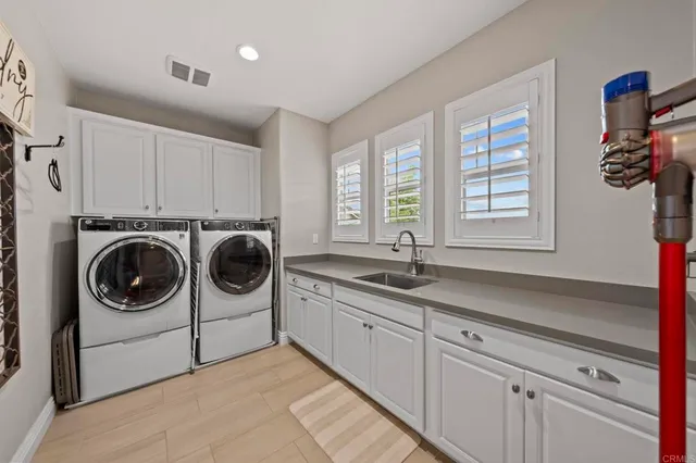 a utility room with sink dryer and washer