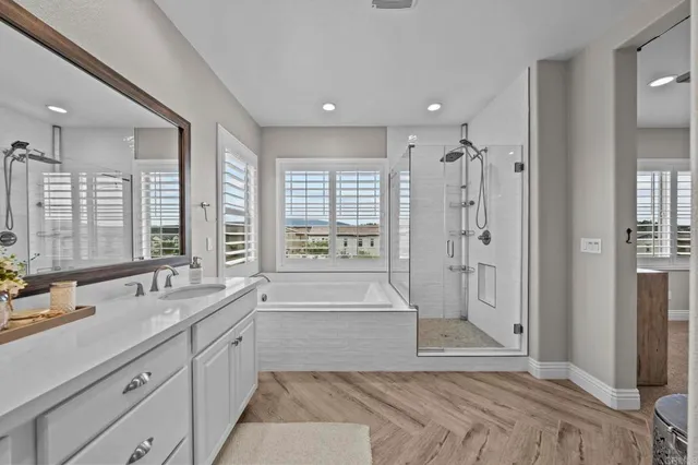 a spacious bathroom with a shower a sink and a large mirror