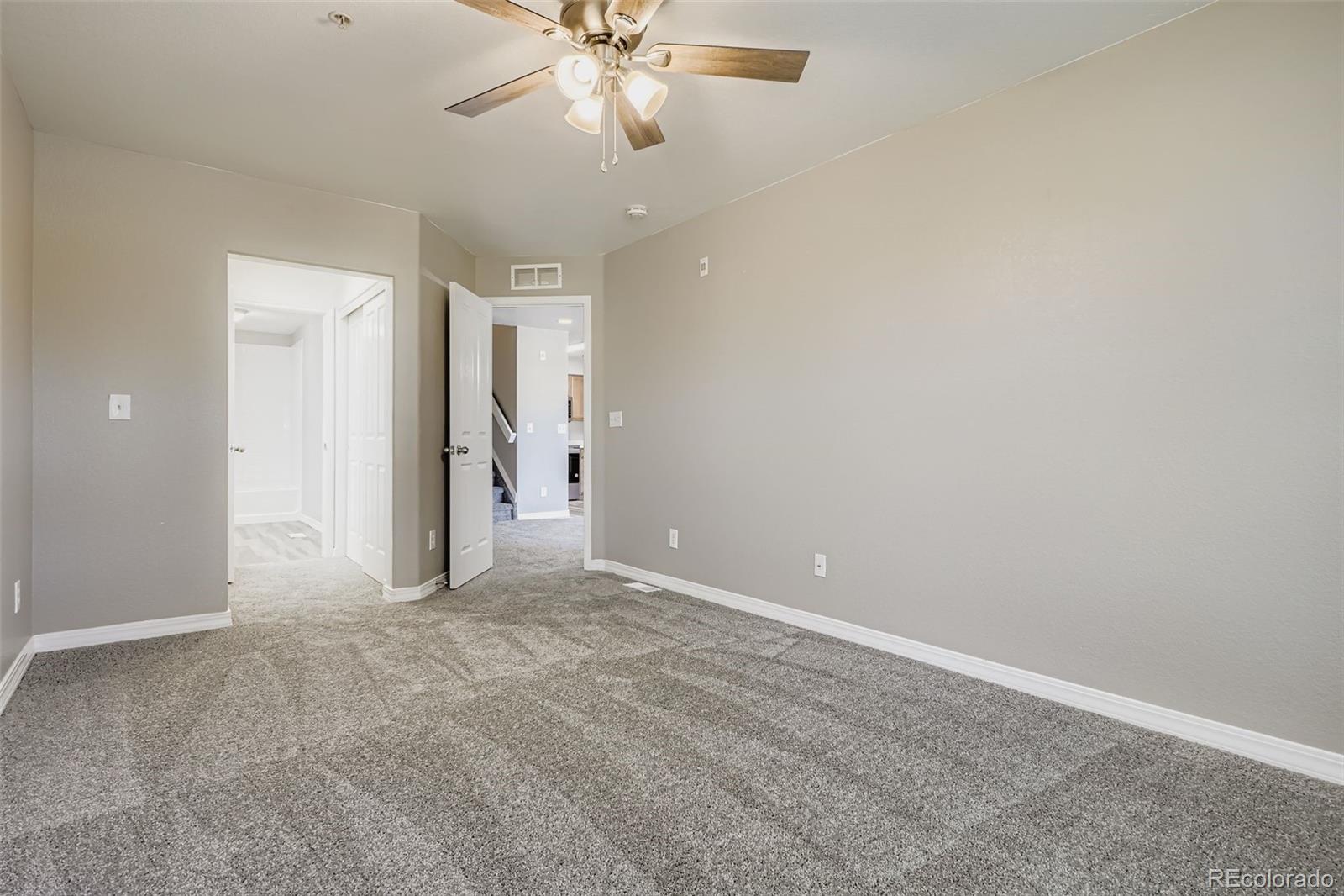 5722 South Addison Way, Unit C Aurora, CO 80016 - Photo 12 of 28 a view of an empty room and chandelier fan
