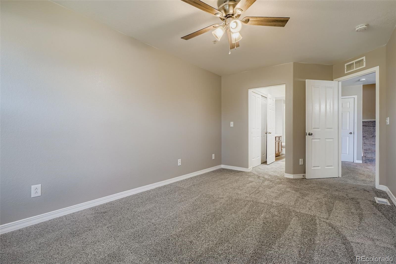 5722 South Addison Way, Unit C Aurora, CO 80016 - Photo 13 of 28 an empty room with closet and a chandelier fan