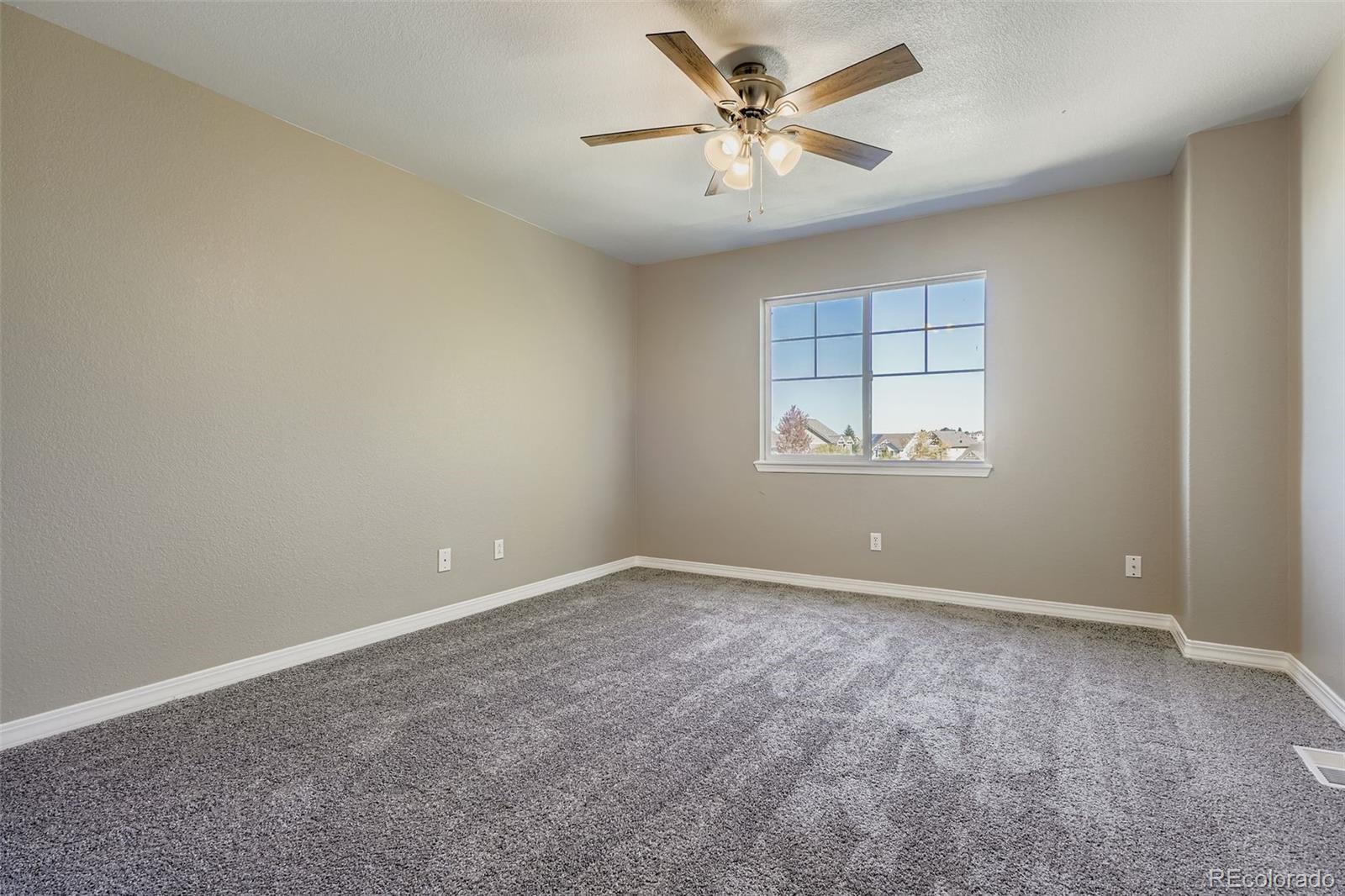 5722 South Addison Way, Unit C Aurora, CO 80016 - Photo 18 of 28 an empty room with a window and a ceiling fan