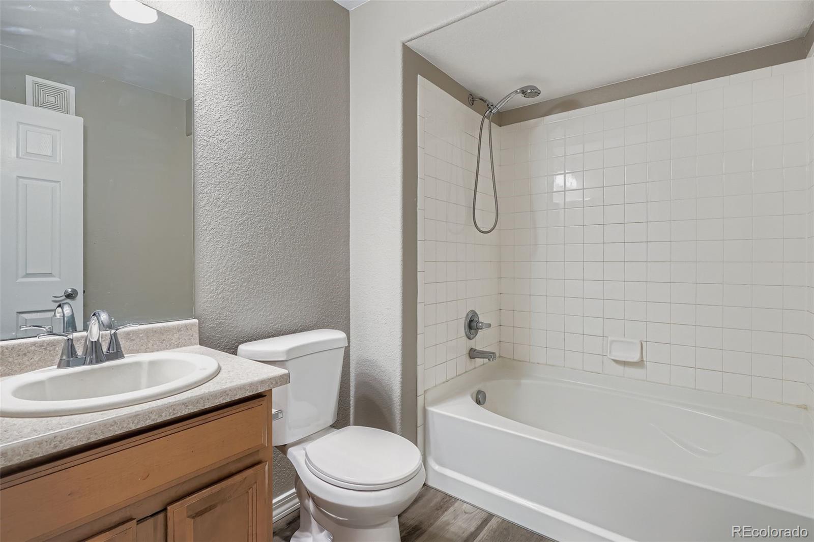 5722 South Addison Way, Unit C Aurora, CO 80016 - Photo 22 of 28 a bathroom with a granite countertop sink a toilet and shower