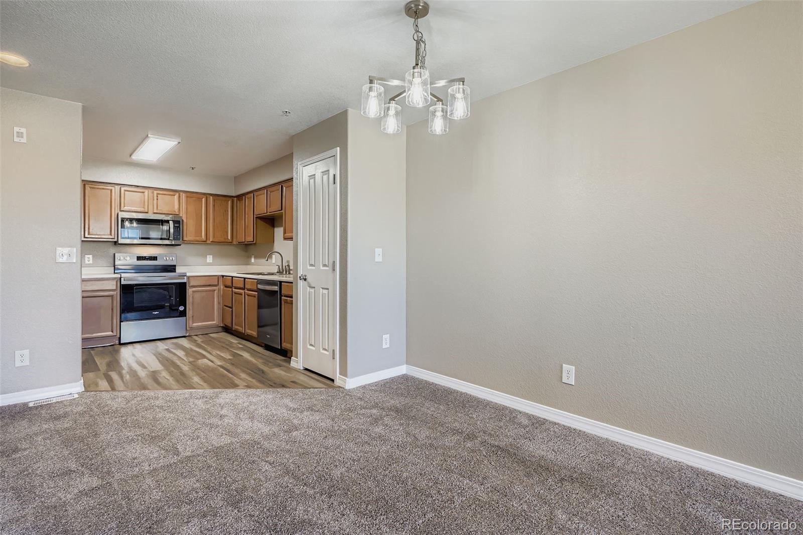 5722 South Addison Way, Unit C Aurora, CO 80016 - Photo 7 of 28 a kitchen with kitchen island stainless steel appliances a sink stove and refrigerator