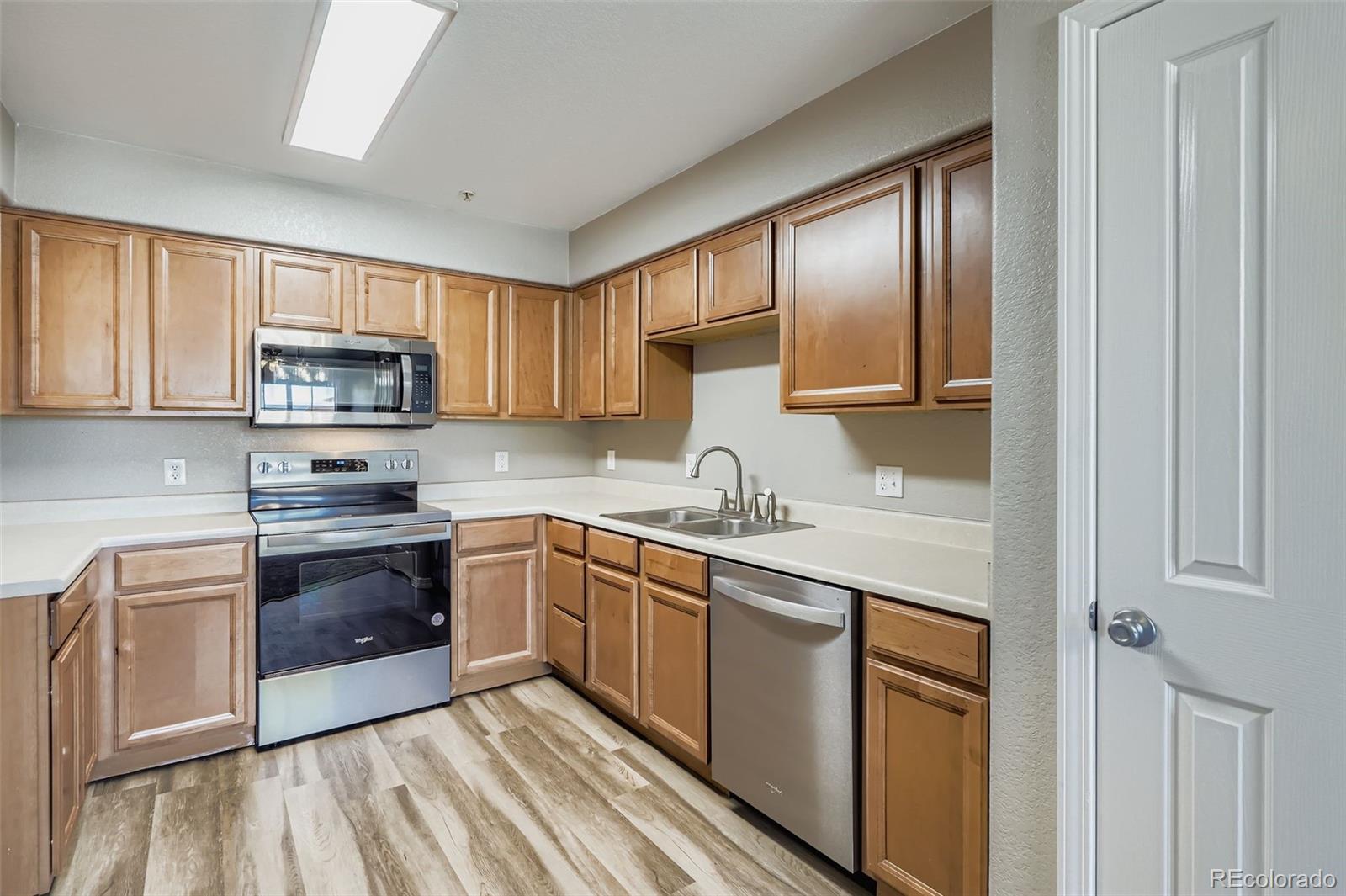 5722 South Addison Way, Unit C Aurora, CO 80016 - Photo 8 of 28 a kitchen with stainless steel appliances granite countertop a stove sink and cabinets