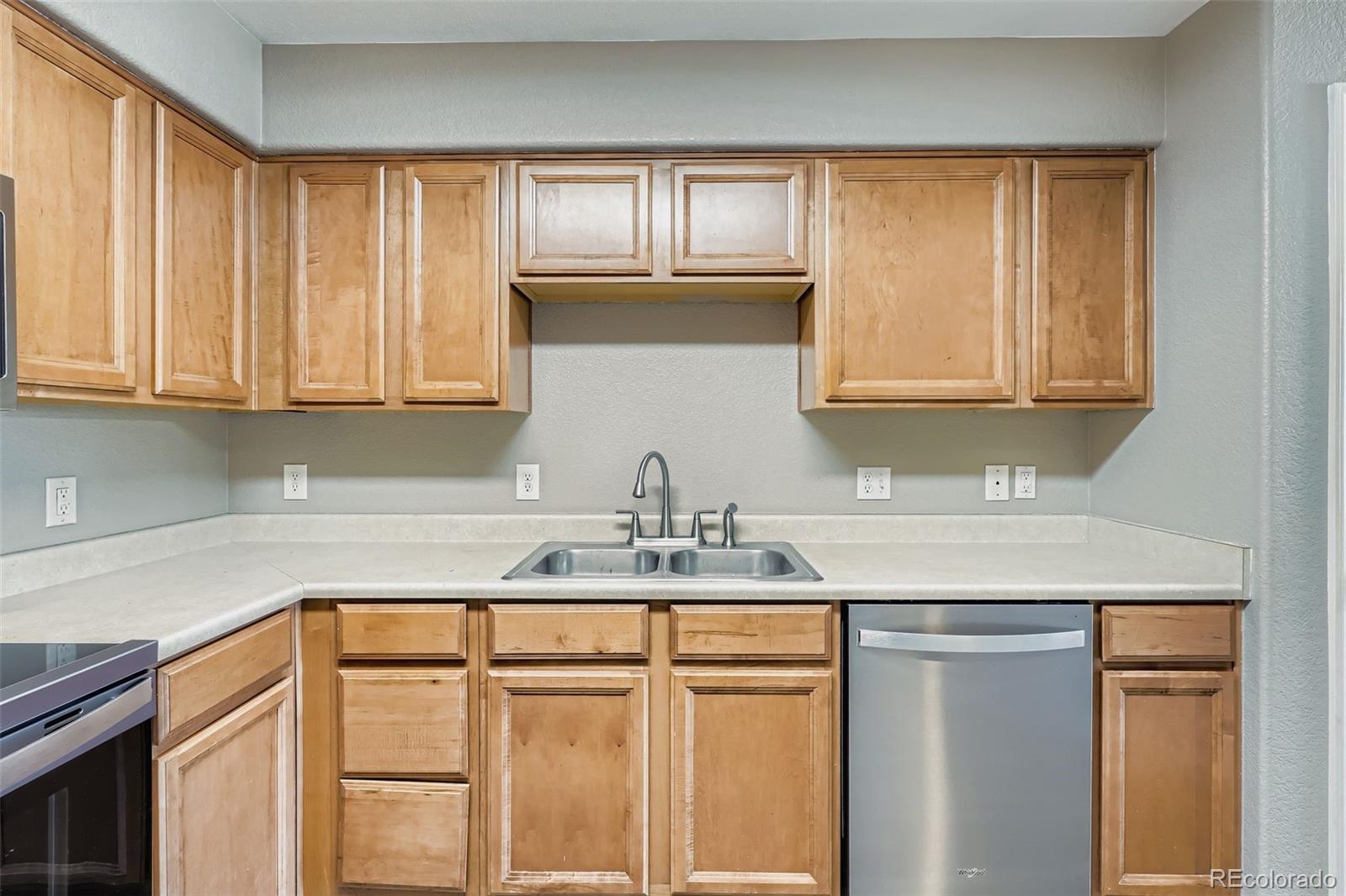 5722 South Addison Way, Unit C Aurora, CO 80016 - Photo 9 of 28 a kitchen with stainless steel appliances granite countertop white cabinets sink and window