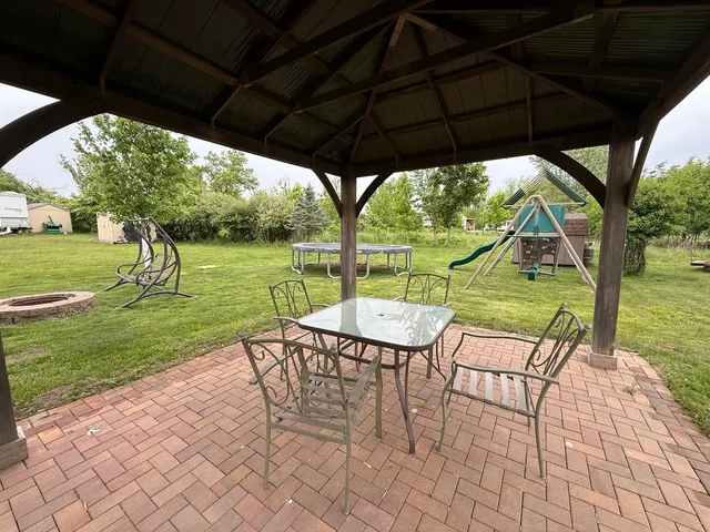 a view of yard with table and chairs under an umbrella