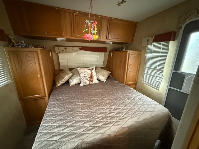 a bedroom with a bed and a mirror on the dresser