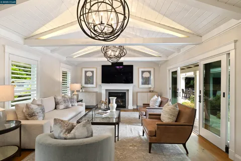 a living room with furniture a chandelier and a fireplace