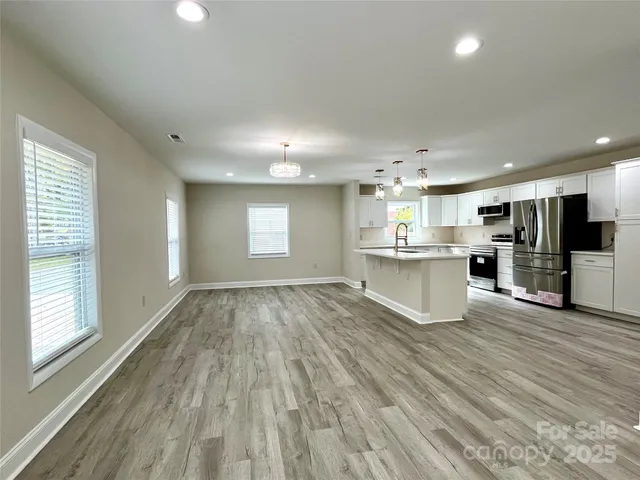 a large kitchen with stainless steel appliances lots of counter space and wooden floor