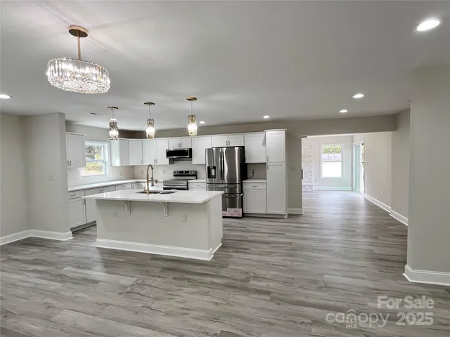 a kitchen with stainless steel appliances a refrigerator sink and microwave