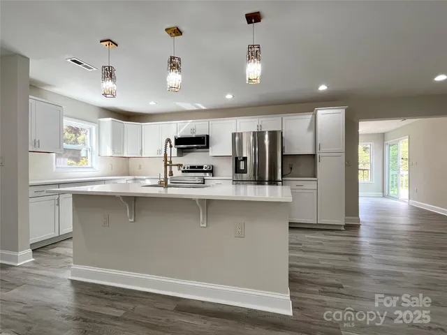 a kitchen with a refrigerator sink and white cabinets