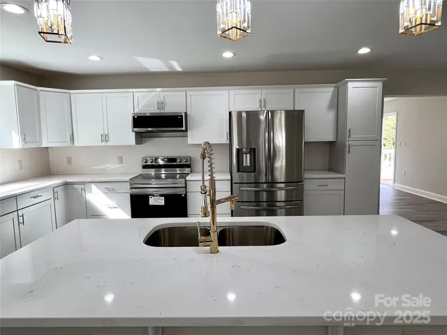 a kitchen with stainless steel appliances a sink a stove and microwave