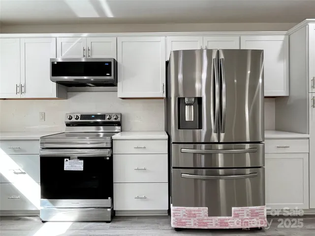 a kitchen with refrigerator and cabinets