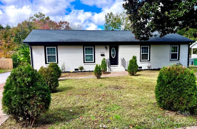 a view of a lake with a bench under large trees