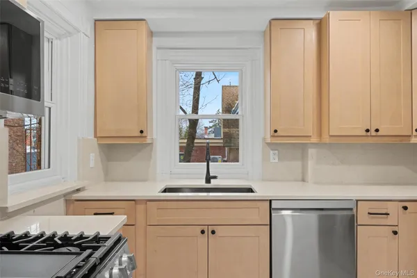 a kitchen with stainless steel appliances a sink stove and cabinets