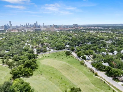 an aerial view of green landscape with trees houses and mountain view