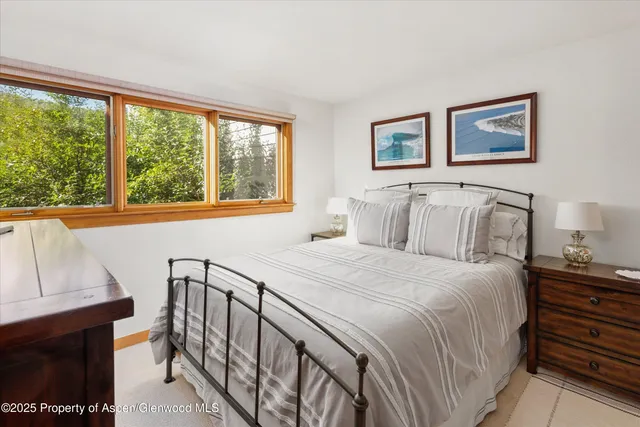 a bedroom with a bed and a large window