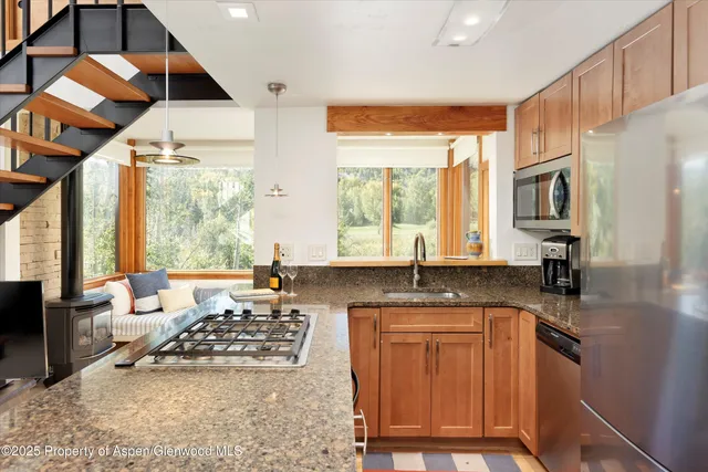 a kitchen with granite countertop a sink and a stove