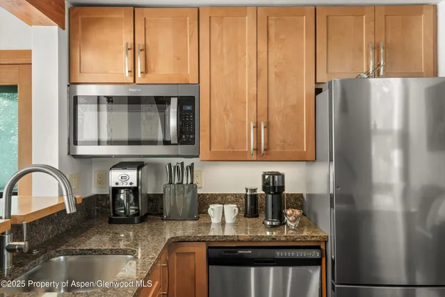 a kitchen with granite countertop a refrigerator and a sink