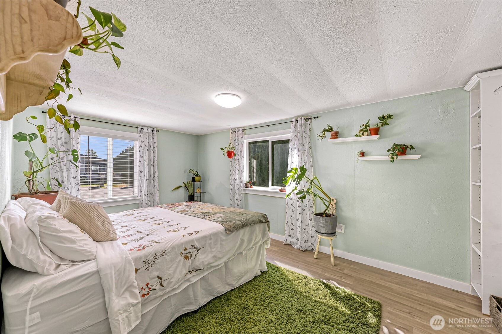1014 West Smith Road, Unit 36 Bellingham, WA 98226 - Photo 18 of 32 a bedroom with a bed a table and potted plant