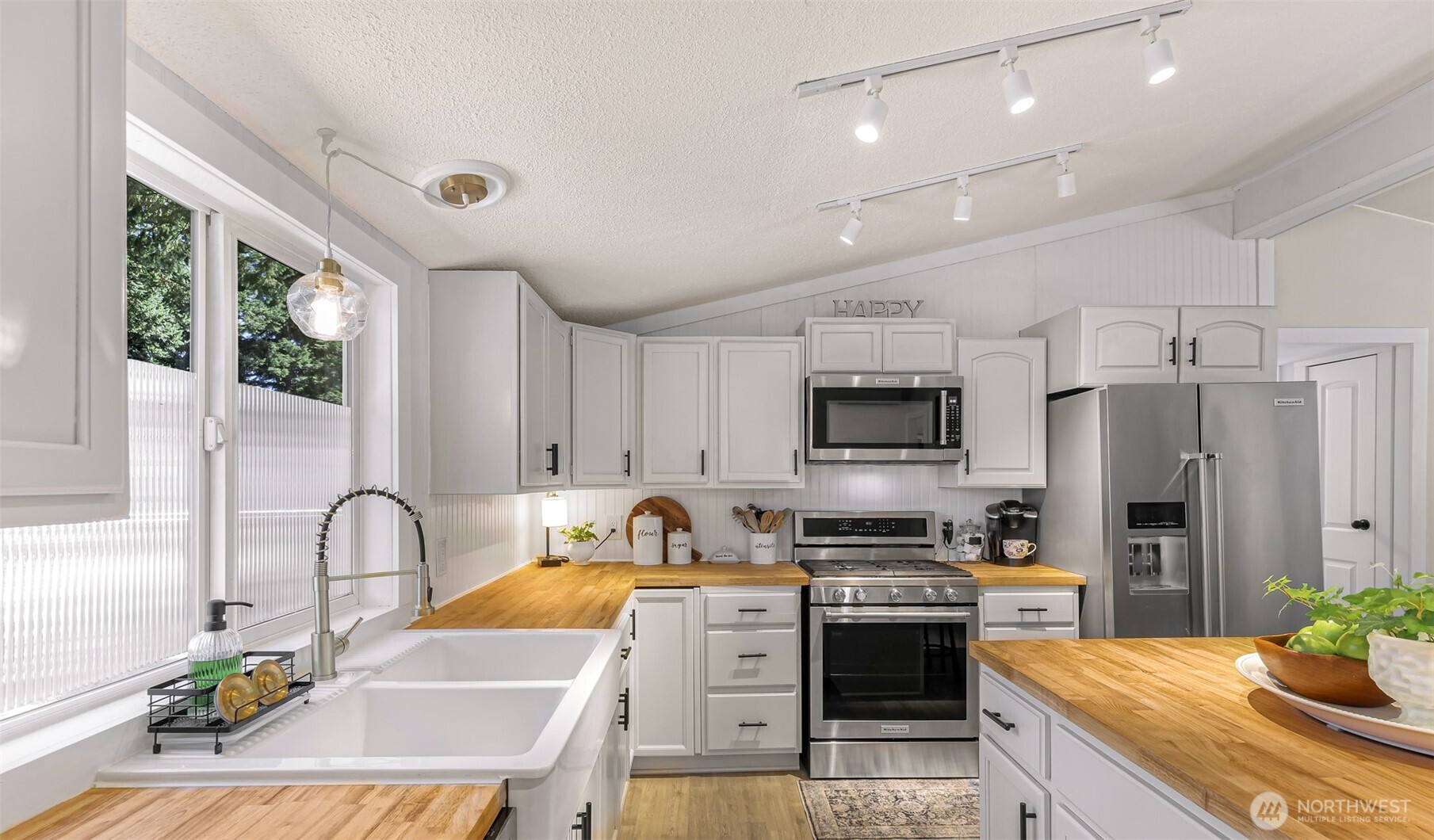 1014 West Smith Road, Unit 36 Bellingham, WA 98226 - Photo 29 of 32 a kitchen with stainless steel appliances granite countertop a stove a sink dishwasher a refrigerator and a microwave with wooden floor