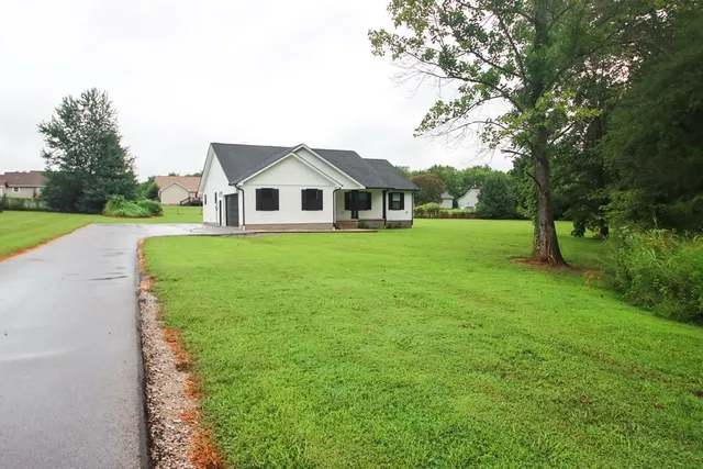 a front view of a house with yard and green space