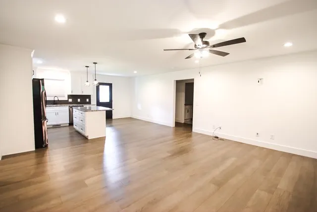 a view of a kitchen with refrigerator stove and wooden floor