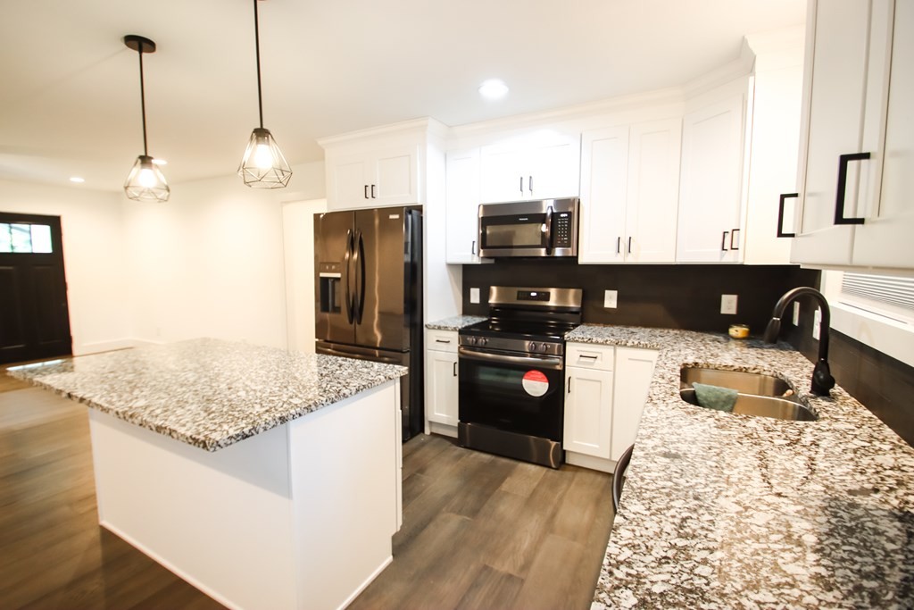 191 Rustling Oaks Drive Sparta, TN 38583 - Photo 10 of 20 a kitchen with stainless steel appliances granite countertop a sink refrigerator and cabinets