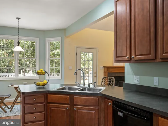 a kitchen with granite countertop wooden floor dining table and chairs