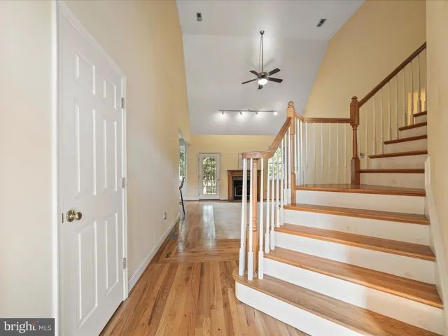 a view of a hallway with wooden floor and staircase