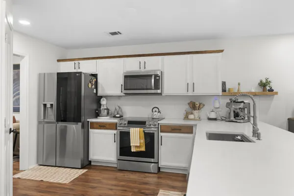 a kitchen with stainless steel appliances granite countertop a refrigerator stove top oven a sink and dishwasher