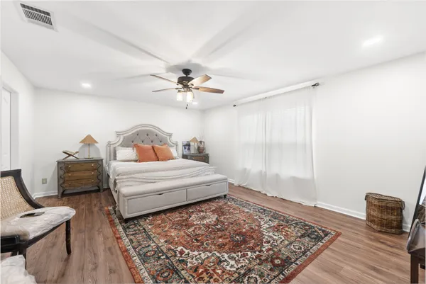 a bedroom with a bed and wooden floor