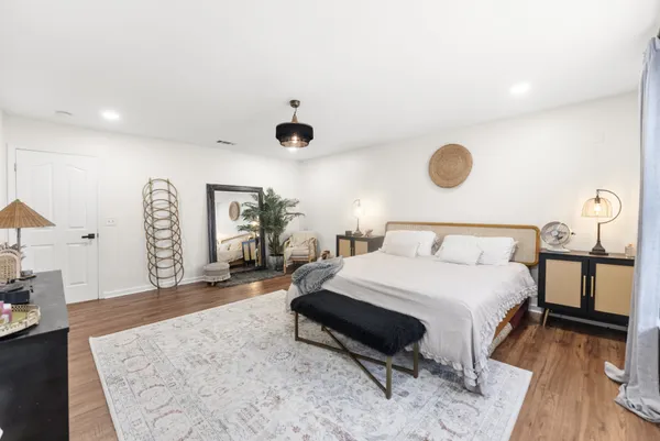 a spacious bedroom with a bed and a chandelier