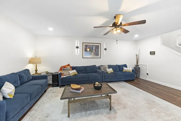a living room with furniture and a ceiling fan