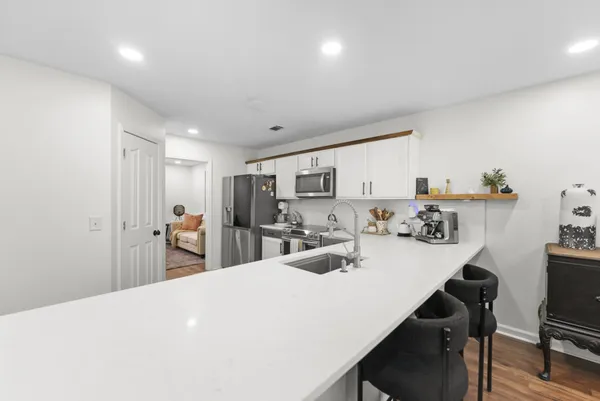 a kitchen with sink a refrigerator and chairs